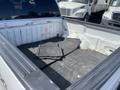 A 2012 Ford F-150 with a clean truck bed featuring rubber floor mats on the floor