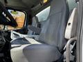 A gray driver's seat and passenger seat of a 2012 Freightliner M2 112 with armrests and a console between them