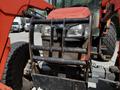 A 2011 Kubota M8540D tractor in the foreground with a distinctive front grille and headlights visible along with a protective metal frame around the front