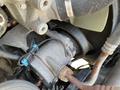 Close-up of a 2022 Freightliner Cascadia engine component featuring a gray metallic part with blue connectors and various pipes attached
