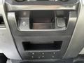 The interior console of a 2017 Ford F-250 SD with a line-in port and a small compartment above a storage space