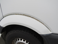 A 2009 Dodge Sprinter Van showing visible rust along the wheel arch with a black tire partially visible.