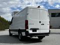 A 2020 Mercedes-Benz Sprinter van with a white exterior viewed from the rear angle showcasing its large cargo space and sleek design