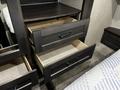 A wooden cabinet with multiple drawers displayed in a partially open position showcasing their interior structure