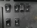 A close-up view of a panel featuring several black switches for controls labeled with icons indicating functions like locked, on, and options