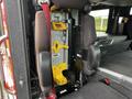 Interior view of a 2009 Spartan Gladiator showing two dark upholstered seats and a mounted gray and yellow equipment rack between them