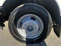 A close-up view of a single tire and wheel from a 2011 Ford F-350 SD featuring a silver rim and rugged black tire tread