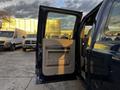 A blue 2008 Ford F-250 SD with its driver side door open showcasing the interior door panel and handle