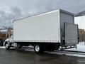 A 2019 Hino 338 24-foot cube truck with a white boxy cargo area and a loading ramp at the rear