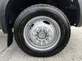 Close-up of a black tire and wheel of a 2007 Ford F-550 with silver rim and distinct tread pattern