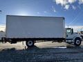 White 2013 International 4300 box truck with a large cargo area and single rear axle parked on a gravel surface