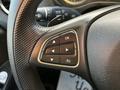 Close-up of a 2022 Mercedes-Benz Metris steering wheel control panel featuring directional arrows and an OK button