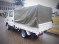 A 2003 Toyota Toyoace with a covered cargo bed and a white exterior parked on a street