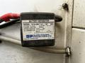 A device labeled battery separator with specifications and instructions, connected by red and black wires to a vehicle's electrical system