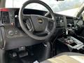 Interior view of a 2013 Chevrolet Express showing the steering wheel dashboard controls and center console with various buttons and a gear shift