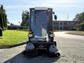 A 2015 Tennant 636 Green Machine street sweeper with a compact design two front brooms and a clear windshield