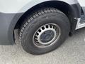 Close-up of a wheel from a 2025 Mercedes-Benz Sprinter featuring a circular rim design and thick tread on the tire