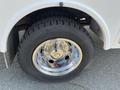 Close-up of a chrome wheel rim mounted on a large tire for a 2015 Ford F-450 SD showing detailed lug nuts and tread pattern