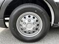 Close-up of a silver alloy wheel with a black tire featuring the Ford logo in the center and a tread pattern designed for multiterrain use