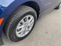 A close-up view of a 2022 Chevrolet Equinox wheel featuring a silver alloy rim and a black tire with visible tread pattern
