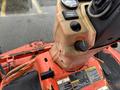 Close-up of the control panel of a 2012 Kubota F3680 showcasing levers gauges and warning labels with wear and dirt visible on the surface