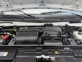 A 2023 Ford E-450 engine compartment showcasing the engine components including the air intake and various hoses and wires