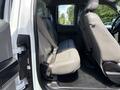 Interior view of a 2016 Ford F-150 showing the rear seating area with gray upholstery and a seatbelt fastened on one of the seats