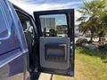 A 2014 Ford F-250 SD with the front door open revealing the interior and armrest with storage compartment