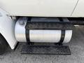 A fuel tank mounted on the side of a 2011 International 4300 with black step plates for access