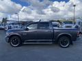 A gray 2017 RAM 1500 pickup truck shown from the side with black rims and a crew cab design
