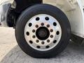 Close-up of a large truck tire showing the metallic wheel rim with multiple bolts and the Goodyear branding on the tire sidewall
