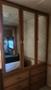 A wooden wardrobe with three mirrored doors and several drawers at the bottom inside a 2007 Winnebago Adventure