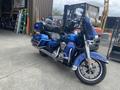 A blue 2017 Harley-Davidson FLHTKL motorcycle with a touring design features a large front windshield dual seats and saddlebags