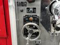 Close-up of the relief valve control panel from a 1991 Sutphen Deluge with various dials and a warning label