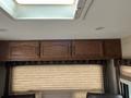 A 2013 Outdoor Wind River with wooden cabinetry and a skylight above the seating area