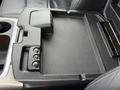 A black plastic storage tray with multiple compartments and a textured surface designed for the center console of a 2018 RAM 1500