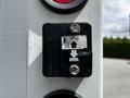 A control panel with a black switch and directional arrows indicating up and down on a white surface