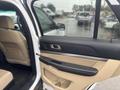 A 2016 Ford Explorer with a tan interior featuring an open door close-up showing the door panel and seat