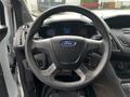 Steering wheel of a 2014 Ford Transit Connect with the Ford logo and control buttons visible on the side