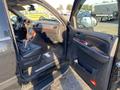 Interior of a 2007 Cadillac Escalade with black leather seats and wooden trim on the dashboard and doors showing an open driver's side door