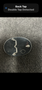 A silver belt buckle with a smooth oval shape features a hook for attachment and a small keyhole detail