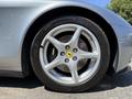 Close-up of a silver 2005 Ferrari 612 Scaglietti wheel featuring five-spoke alloy design with a yellow Ferrari logo center cap and Michelin tire