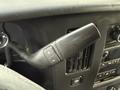 Close-up of the gear shift lever inside a 2015 GMC Savana with buttons for gear selection and an air vent nearby