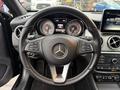 Steering wheel of a 2016 Mercedes-Benz GLA-250 with control buttons and the Mercedes-Benz logo prominently displayed in the center