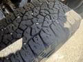 Close-up of a worn tire tread on a 2016 GMC Sierra 1500 showing deep grooves and uneven surface texture