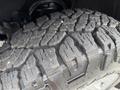 Close-up of a rugged tire tread on a 2016 GMC Sierra 1500 showcasing deep grooves and a durable design for off-road performance
