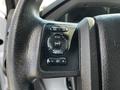 Close-up of the control panel on the steering wheel of a 2016 Ford F-550 highlighting buttons for setup info reset and volume adjustments