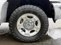 Close-up of a silver alloy wheel on a 2016 Ford F-350 SD with a rugged all-terrain tire showcasing deep treads and a complex wheel design