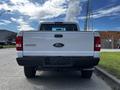 A rear view of a white 2010 Ford Ranger with the brand name and model displayed on the tailgate