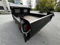 A 2015 Mitsubishi Fuso FE dump truck with an empty open bed and metal tailgate positioned at an angle